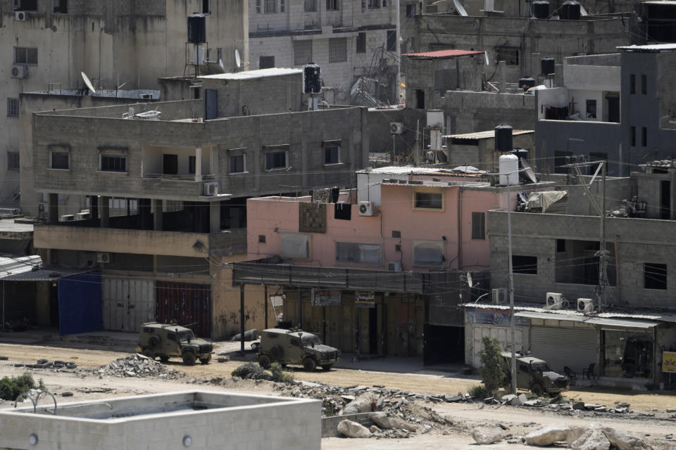 Israeli military vehicles drive during a military operation in the nearby Nur Shams refugee camp, near the West Bank town of Tulkarem, Saturday, April 20, 2024. The raid killed at least four Palestinians, including three militants, according to the Israeli military, Palestinian health officials and the Islamic Jihad militant group. (AP Photo/Majdi Mohammed)