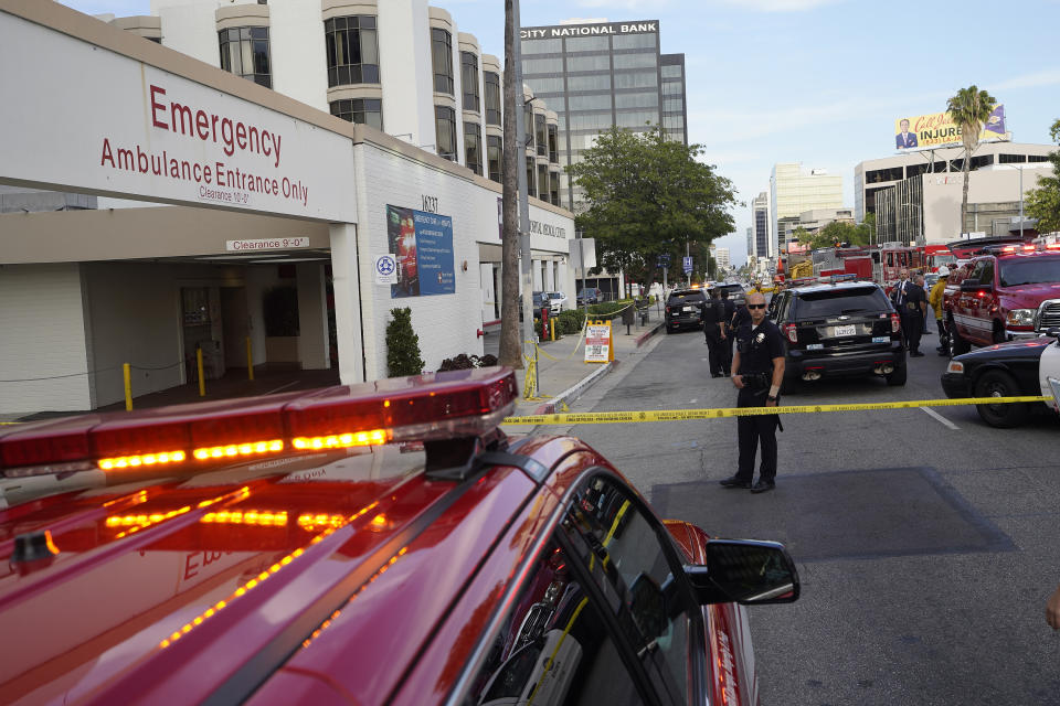 Police and emergency personnel stand outside Encino Hospital Medical Center on Friday, June 3, 2022, in Los Angeles. A man stabbed a doctor and two nurses inside the hospital's emergency ward Friday and remained inside a room for hours before police arrested him, authorities said. (AP Photo/Damian Dovarganes)