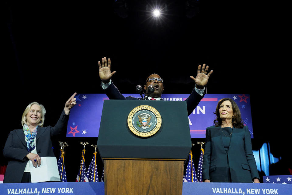 Rep. Jamaal Bowman stands at a podium. He is flanked by New York Sen. Kirsten Gillibrand and New York Gov. Kathy Hochul.