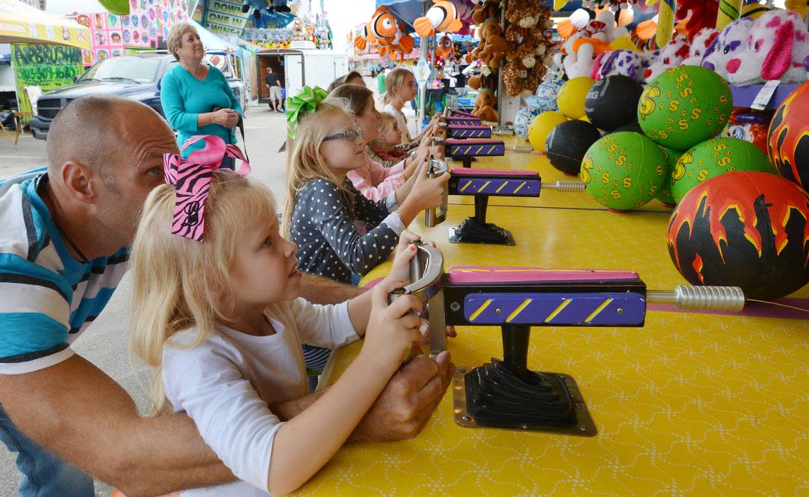 Lilly Wood, 5 (left) and her sister Ava Wood, 9, help the Wake County Sheriff’s gaming squad check out the Top Spin Water Race game at the State Fairgrounds in Raleigh, NC Wednesday Oct 16, 2013. The Sheriff’s Department checks out all the games to make sure they are on the “up and up” before the fair opens.