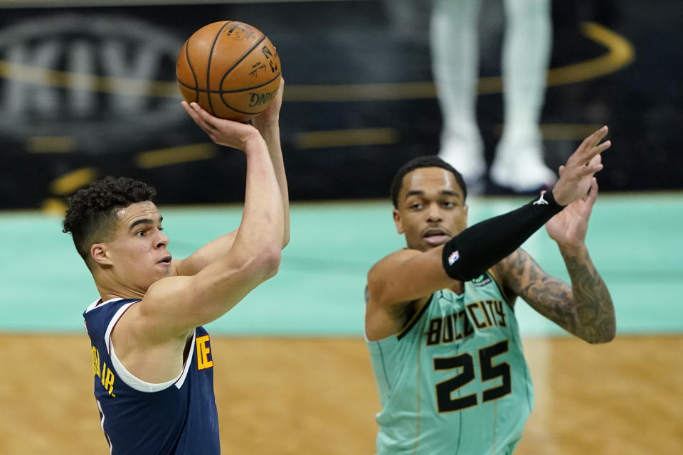 Denver Nuggets forward Michael Porter Jr. scores as Charlotte Hornets forward P.J. Washington looks on during the first half of an NBA basketball game on Tuesday, May 11, 2021, in Charlotte, N.C. (AP Photo/Chris Carlson)