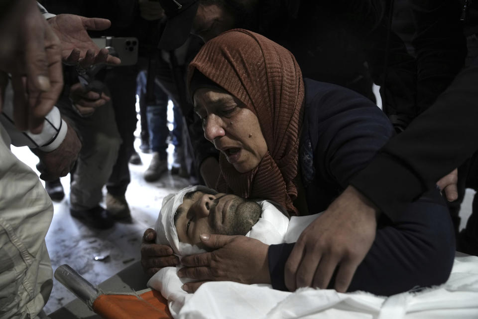 Nassim Abu Fouda is embraced by his mother at his funeral in Hebron, Monday, Jan. 30, 2023. Israeli forces shot and killed the Palestinian man in the flashpoint city in the occupied West Bank on Monday, the Palestinian Health Ministry said. The killing marks the latest bloodshed in spiraling violence that comes as U.S. Secretary of State Antony Blinken visits the region. (AP Photo/ Mahmoud Illean)