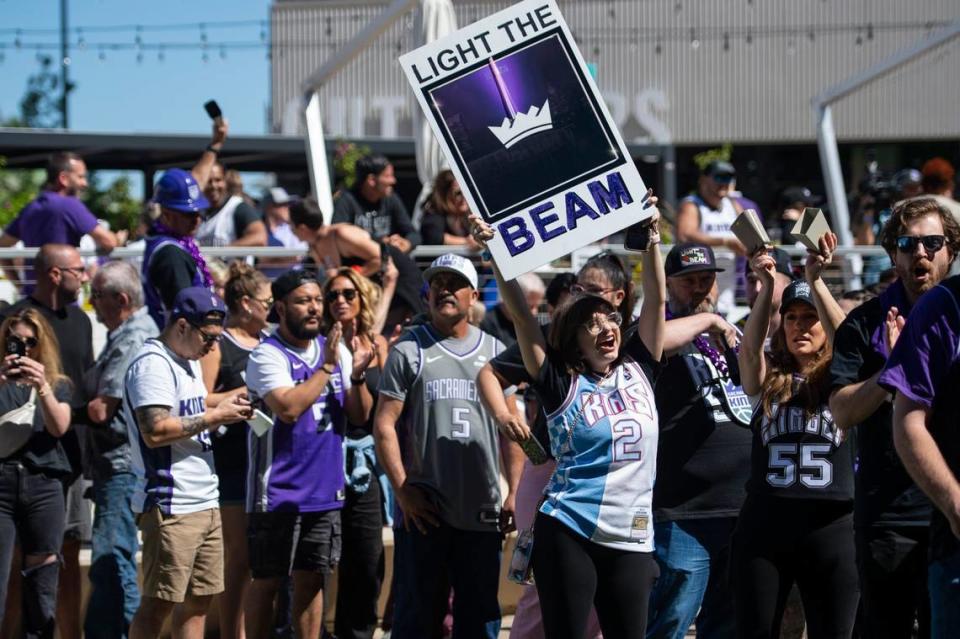 A fan waves a “light the beam” sign as the crowd waits to enter Golden 1 Center for Game 7 of the first-round NBA playoff series between the Sacramento Kings and the Golden State Warriors on Sunday.