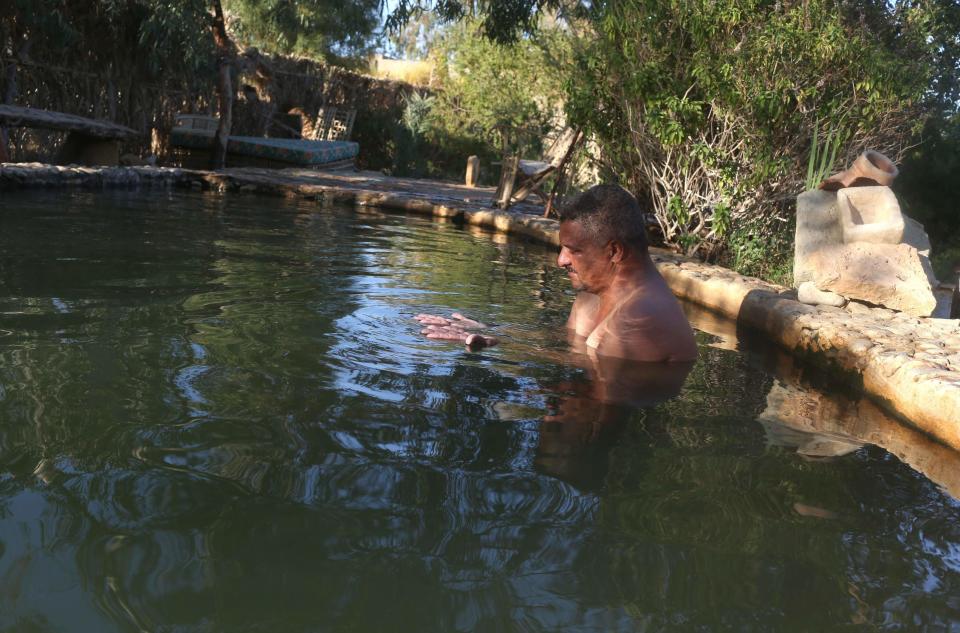 A man bathes in a natural hot water spring which is full of minerals