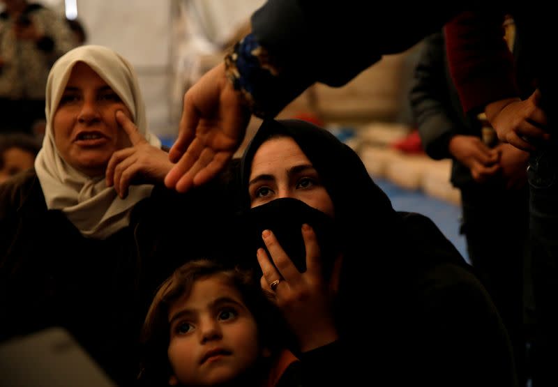 Internally displaced Syrian women and their children sit in a tent in an IDP camp located near Idlib