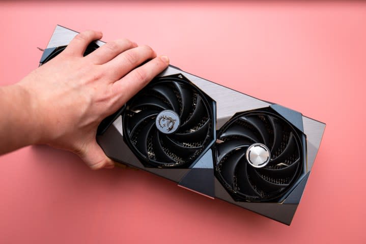 A hand grabbing MSI's RTX 4090 Suprim X.