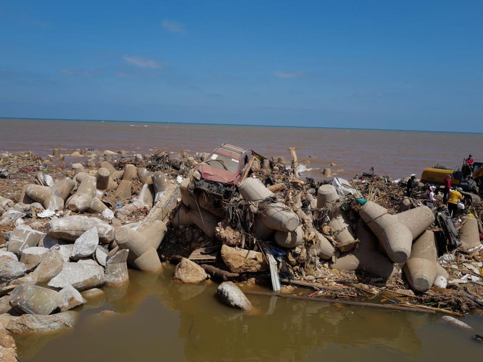 A car,  carried away by the flood water, is seen at the sea front in Derna.