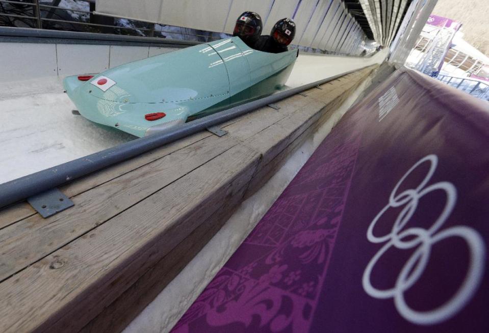 The JPN-1 team from Japan brake in the finish area after a training run for the men's two-man bobsled at the 2014 Winter Olympics, Wednesday, Feb. 5, 2014, in Krasnaya Polyana, Russia. (AP Photo/Michael Sohn)