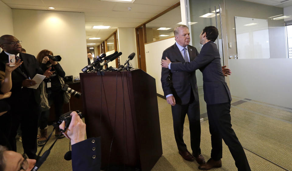 Seattle Mayor Ed Murray, second from right, is greeted by his husband, Michael Shiosaki, after reading a statement to the media, Friday, April 7, 2017, in Seattle. A lawsuit filed Thursday accuses Murray of sexually molesting a teenage high-school dropout in the 1980s, and in interviews with The Seattle Times, two other men claim he abused them. The mayor denied the allegations through his personal spokesman Jeff Reading. (AP Photo/Elaine Thompson)