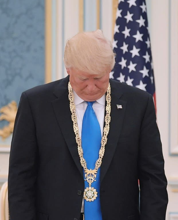 US President Donald Trump looks at the Order of Abdulla al-Saud medal which he received from Saudi Arabia's King Salman at the Saudi Royal Court in Riyadh on May 20, 2017