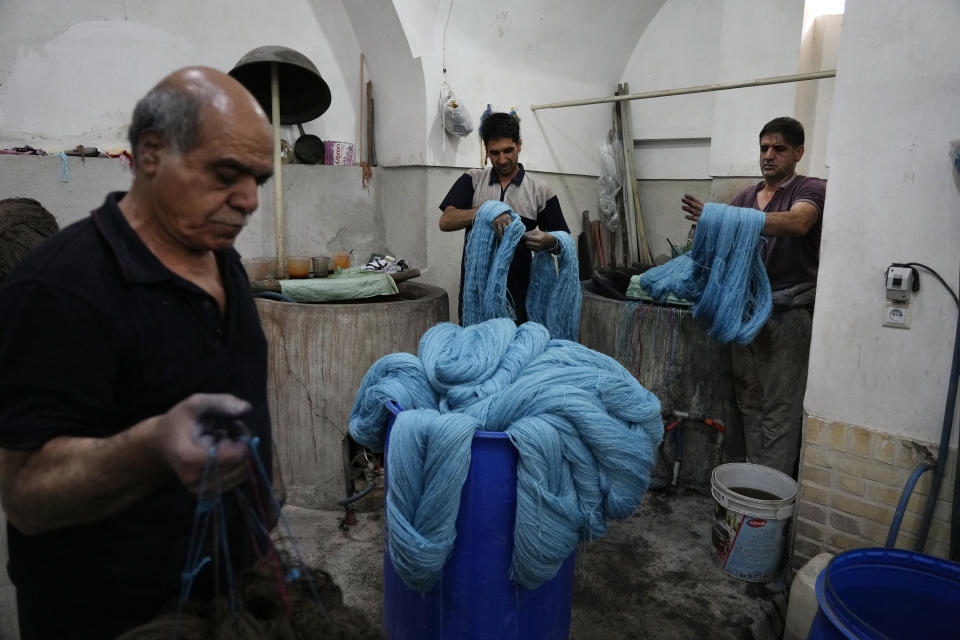 Iranian dyers dye batches of thread for hand-woven carpets at a workshop at the traditional bazaar of the city of Kashan, about 152 miles (245 km) south of the capital Tehran, Iran, Tuesday, April 30, 2024. (AP Photo/Vahid Salemi)