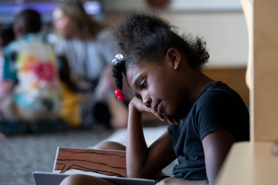 Alayah Thompson, a first grade student in Sarah Lofquist’s class at Pleasant Ridge Montessori School, reads during silent reading time  May 24.