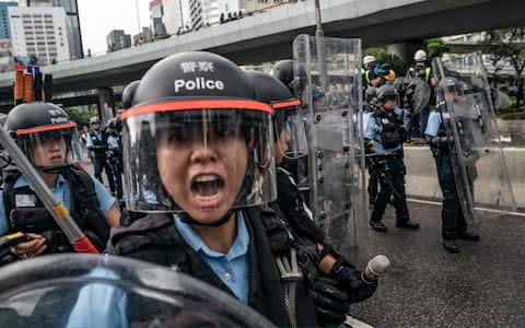 Police officers use baton to disperse anti-extradition protesters during a clash outside the Legislative Council Complex  - Credit: Getty