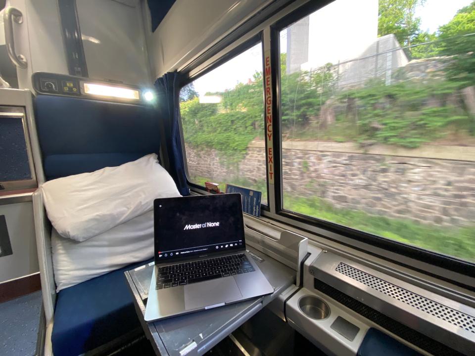 a room with a table and laptop on amtrak train