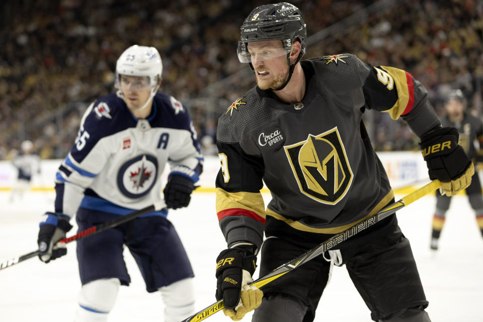 Vegas Golden Knights center Jack Eichel (9) and Winnipeg Jets center Mark Scheifele, left, watch the puck during the third period in an NHL hockey game, Sunday, Oct. 30, 2022, in Las Vegas. (AP Photo/Ellen Schmidt)