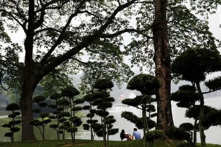 A couple talk in the park on a hazy day in Kuala Lumpur, Malaysia, October 18, 2015. REUTERS/Olivia Harris