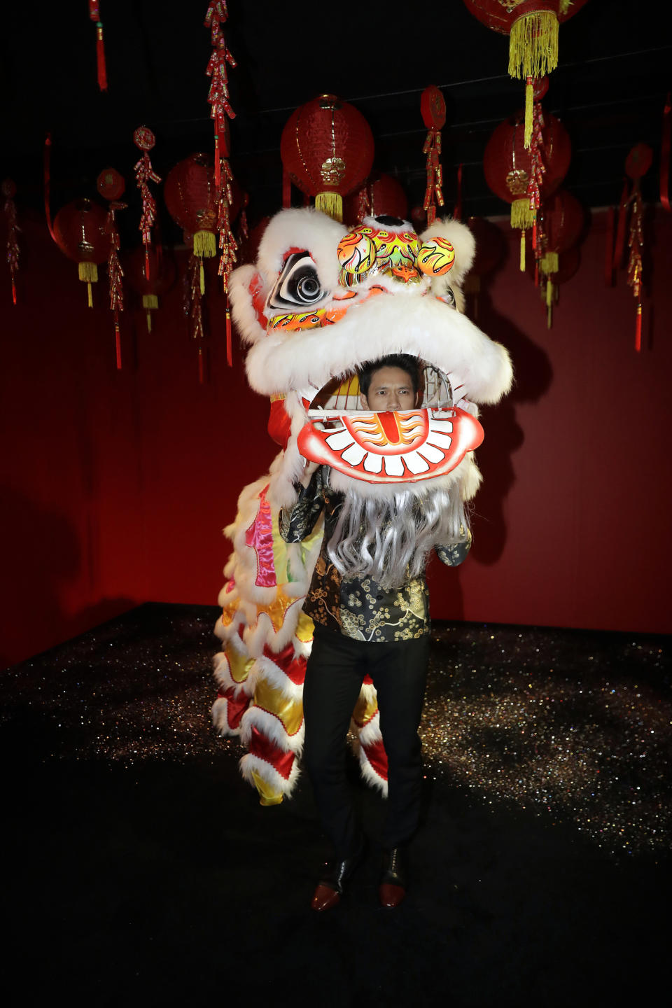 CORRECTS CITY TO LOS ANGELES - Actor Harry Shum Jr. gets inside of a a Chinese dragon during the opening of a Lunar New Year installation Thursday, Jan. 31, 2019 in Los Angeles. Chinese fast-food chain Panda Express funded the New Year's-themed interactive exhibit inside the Westfield Century City mall. (AP Photo/Marcio Jose Sanchez)