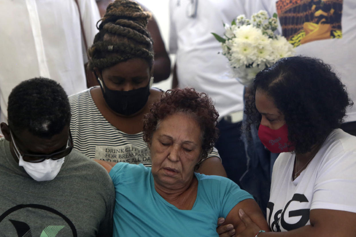 Supported by relatives, Angela Romeu, center, the grandmother of Kathlen Romeu, a young pregnant woman killed by a stray bullet, attends her granddaughter's funeral in Rio de Janeiro, Brazil, Wednesday, June 9, 2021. Rio’s police have said the 20-something interior designer was hit by a single shot in her torso during a shootout with criminals. Officers brought her to a nearby hospital, but neither she nor her baby survived. (AP Photo/Bruna Prado)