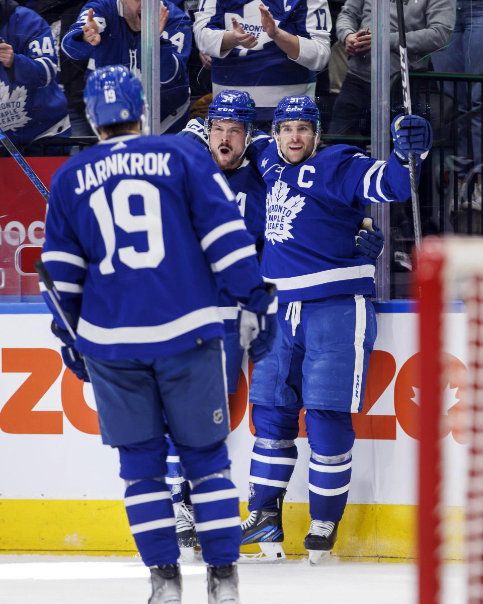 Toronto Maple Leafs center John Tavares (91) celebrates his goal against Edmonton Oilers goaltender Stuart Skinner (74) alongside center Calle Jarnkrok (19) and center Auston Matthews (34) during the second period of an NHL hockey game in Toronto, Saturday, March 11, 2023. (Cole Burston/The Canadian Press via AP)