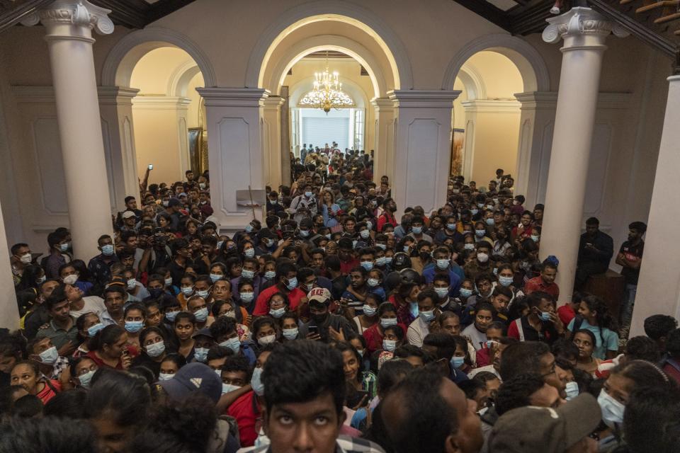 People struggle as they enter the president's official residence a day after it was stormed in Colombo, Sri Lanka, Monday, July 11, India, July 11, 2022. The image was part of a series of images by Associated Press photographers that was a finalist for the 2023 Pulitzer Prize for Breaking News Photography. (AP Photo/Rafiq Maqbool)