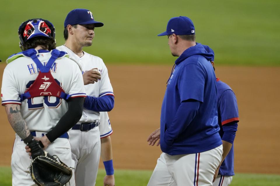 Texas Rangers catcher Jonah Heim (28) stands by as starting pitcher Kohei Arihara, second from left, gets a visit from pitching coach Doug Mathis, right, in the fifth inning of a baseball game against the Houston Astros in Arlington, Texas, Wednesday, Sept. 15, 2021. (AP Photo/Tony Gutierrez)