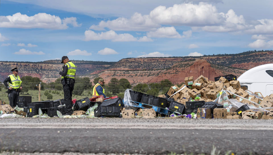 This Thursday, Aug. 30, 2018 photo shows investigators at the scene of the collision of a semitruck that crossed the median of Interstate 40 and crashed head-on into a Greyhound bus near Thoreau, N.M. A California-based trucking company and one of its drivers were accused of negligence Friday in a pair of lawsuits as investigators sorted through the wreckage from the deadly bus crash on the New Mexico highway. (Brandon N. Sanchez/Gallup Independent via AP)