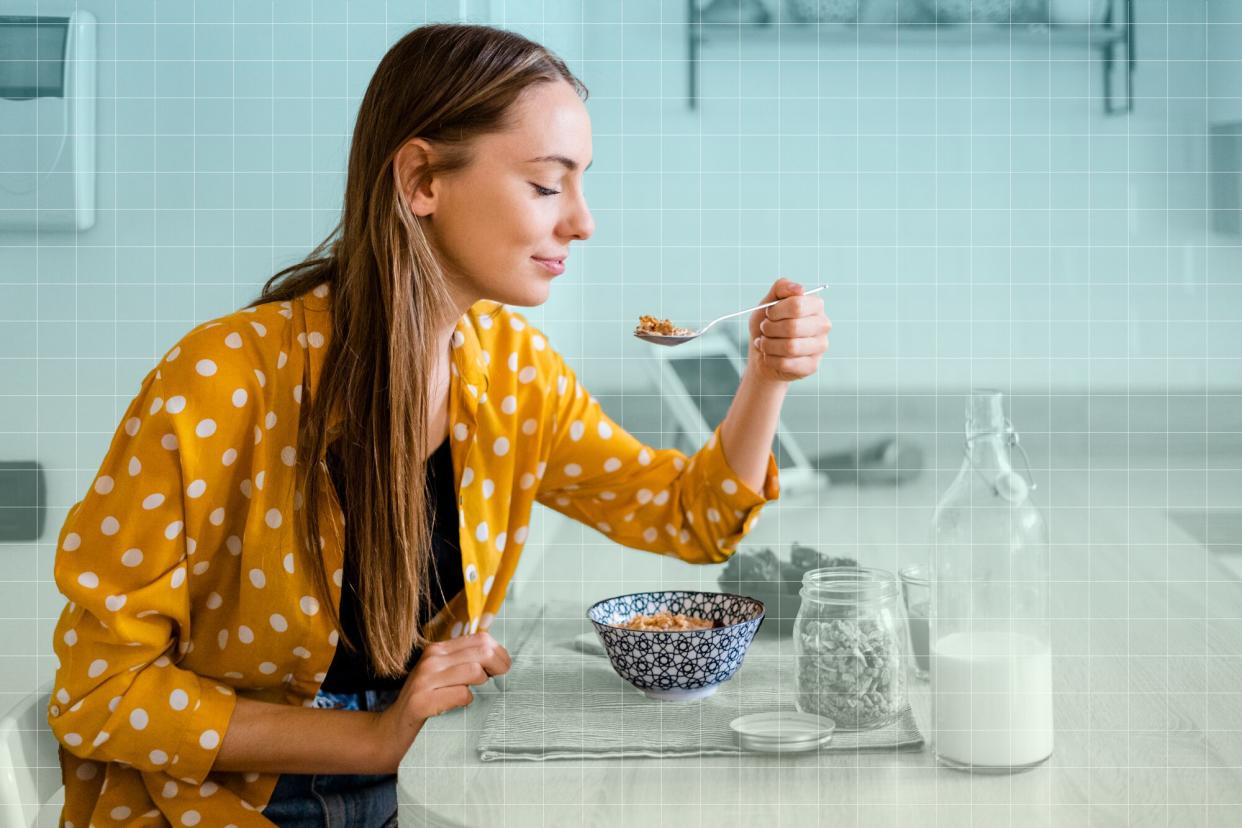 a photo of a woman eating from a bowl while sitting at her kitchen counter