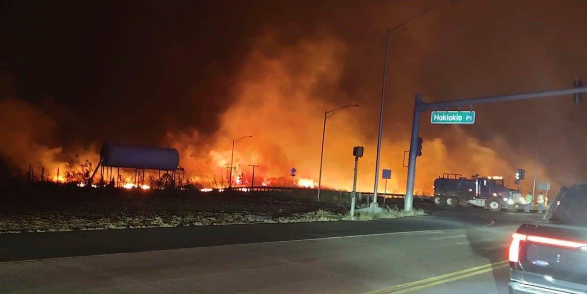 This photo provided by County of Maui shows fire and smoke filling the sky from wildfires on the intersection at Hokiokio Place and Lahaina Bypass in Maui, Hawaii on Tuesday, Aug. 8, 2023 (Zeke Kalua/County of Maui via AP)