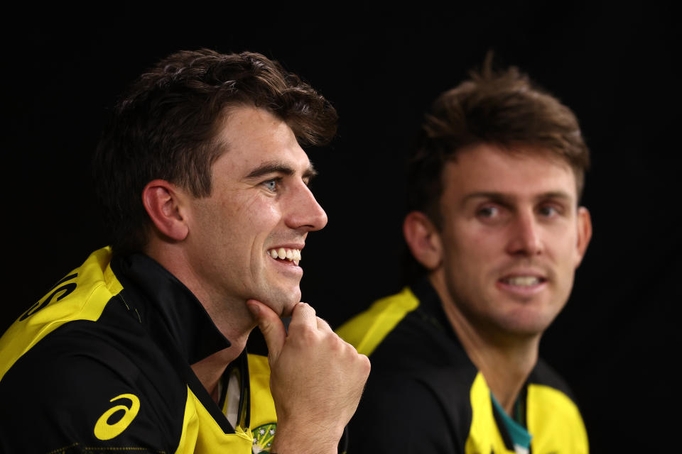 Pat Cummins (pictured left) looks on from the Australian dug out.