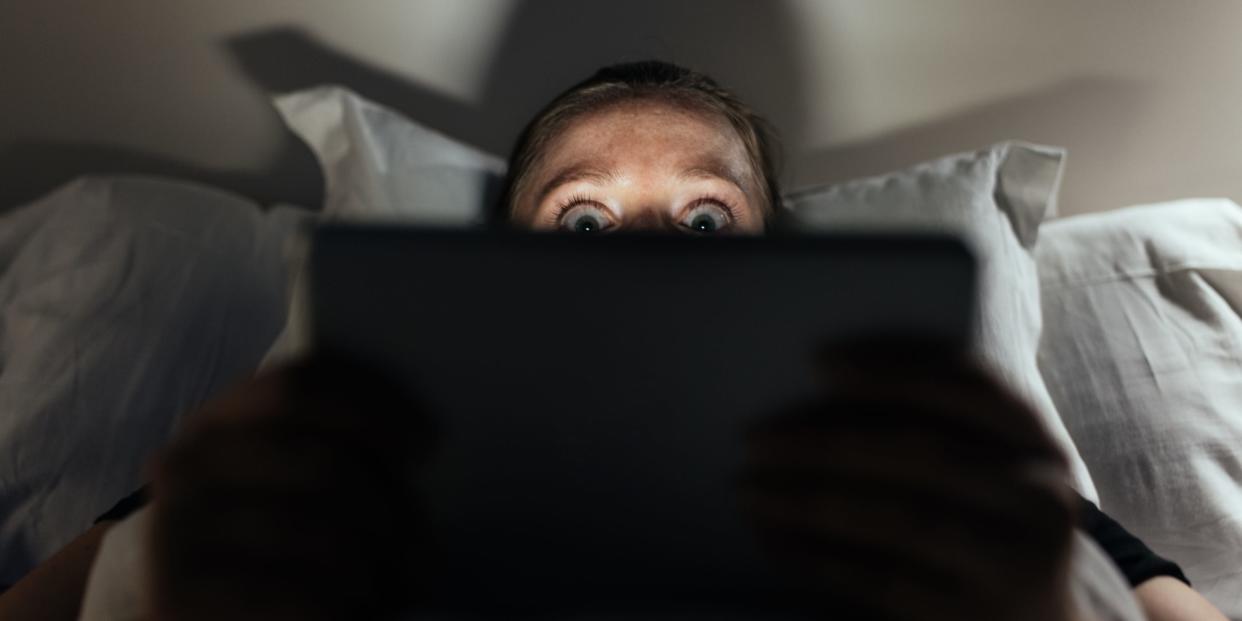 Woman scared watching on a laptop