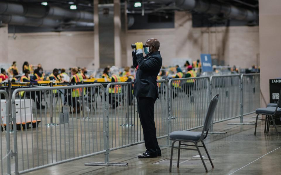 A poll watcher at a count in Philadelphia on November 3. The Trump campaign has claimed that observers were not permitted to view ballots being counted - BLOOMBERG