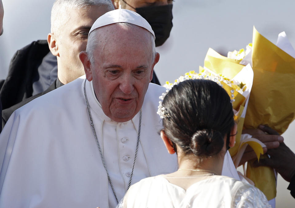 Children give Pope Francis, center, flowers as he arrives at Irbil International Airport, Iraq, Sunday, March 7, 2021. Francis is urging Iraq’s long-suffering Christians to forgive the injustices committed against them by Muslim extremists. He asks them to persevere to rebuild the country after years of war and sectarian conflicts. (AP Photo/Hadi Mizban)