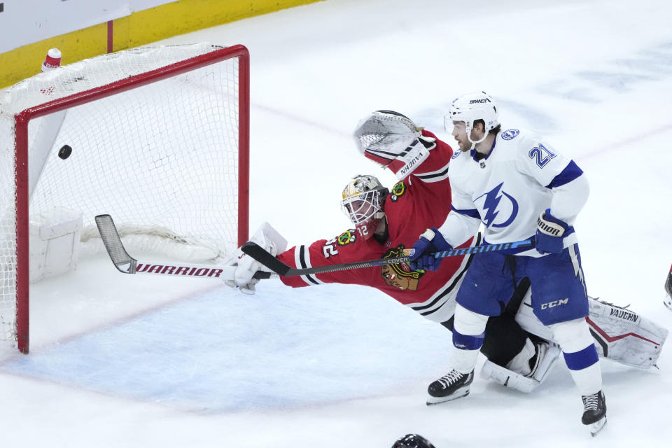 Chicago Blackhawks goaltender Alex Stalock reaches for a shot by Tampa Bay Lightning's Brandon Hagel that ricocheted off the cross bar as Brayden Point watches during the second period of an NHL hockey game Tuesday, Jan. 3, 2023, in Chicago. (AP Photo/Charles Rex Arbogast)