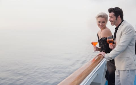 Couple relaxing on deck of cruise - Credit: Getty