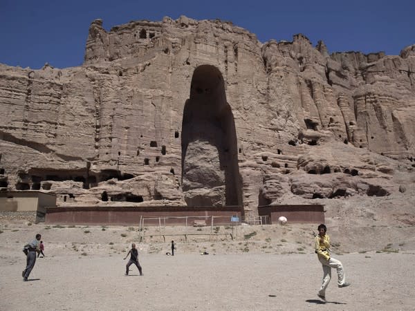 Afghan boys play soccer in front of the remains of a 1,500-year-old Buddha statue on August 22, 2011. (Image credit: Reuters)