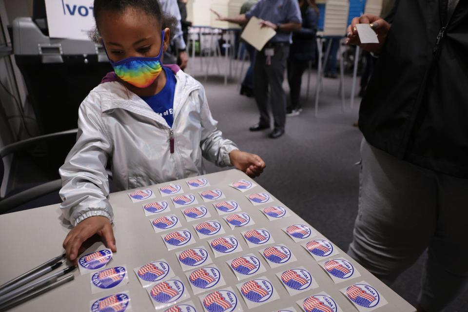 Five-year-old Savannah Angel Harris picks up a sticker reading 