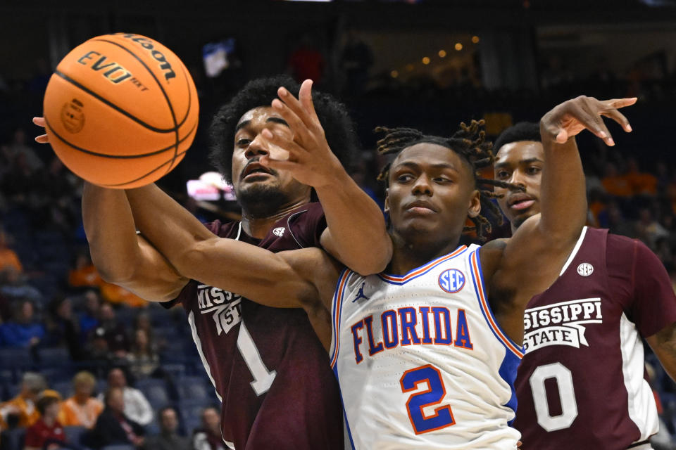 Mississippi State forward Tolu Smith (1) and Florida guard Trey Bonham (2) battle for the ball during the first half of an NCAA college basketball game in the second round of the Southeastern Conference Tournament, Thursday, March 9, 2023, in Nashville, Tenn. (AP Photo/John Amis)