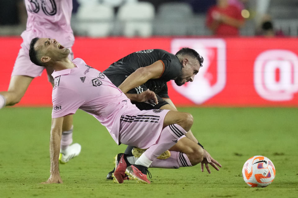 Inter Miami midfielder Sergio Busquets, left, collides with Houston Dynamo midfielder Héctor Herrera (16) in the first half of the U.S. Open Cup final soccer match, Wednesday, Sept. 27, 2023, in Fort Lauderdale, Fla. (AP Photo/Rebecca Blackwell)