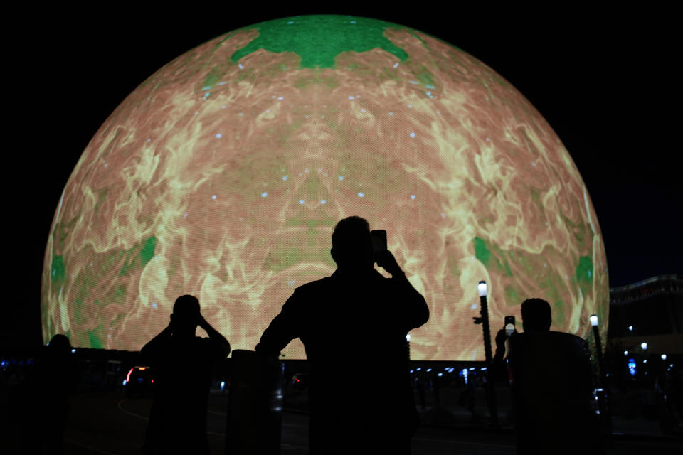 Personas toman fotografías en la inauguración del foro Sphere, el viernes 29 de septiembre de 2023 en Las Vegas. U2 inauguró el foro con el primer concierto de su residencia “UV Achtung Baby”. (Foto AP/John Locher)