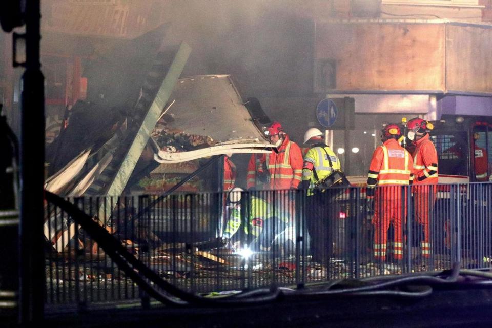 Emergency services work at the scene of the blast (PA)