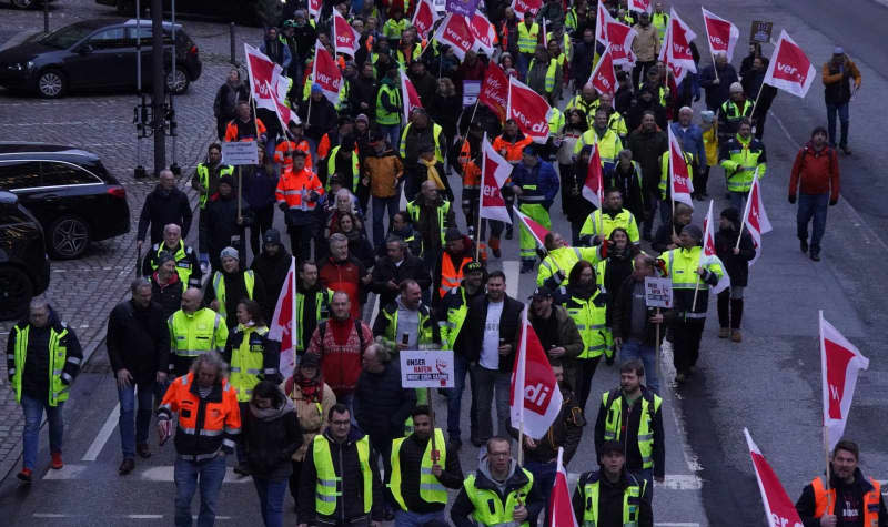 People take part in a demonstration in the Speicherstadt called by The Verdi trade union against the sale of shares in Hamburger Hafen und Logistik AG (HHLA) to the Italian shipping company MSC. Marcus Brandt/dpa