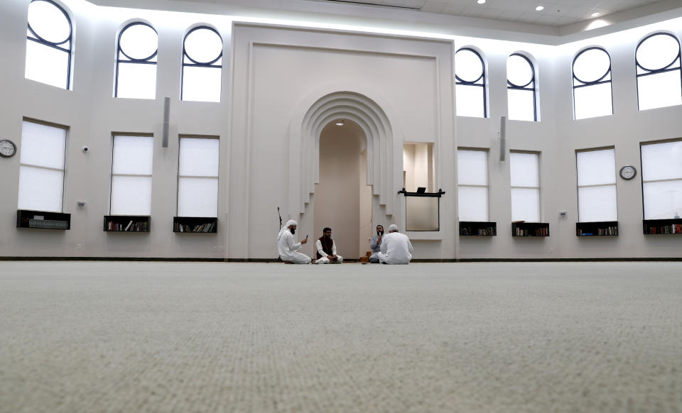 Amid concerns of the spread of COVID-19, a small group prays inside an empty mosque before an Eid al-Fitr celebration in Plano, Texas, Sunday, May 24, 2020. (AP Photo/LM Otero)