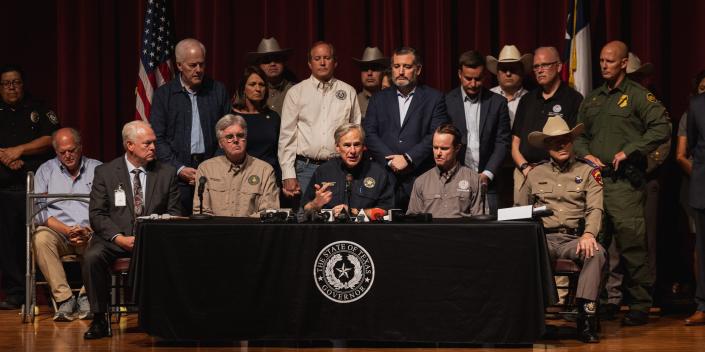 Texas officials sit on a stage giving a press conference.
