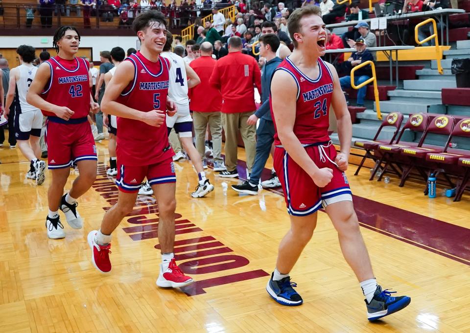 Martinsville’s Zhane Capshaw (42), Jace LaFary (5) and Grady Gardner (24) celebrate after defeating Bloomington South, 65-61, in the IHSAA boys’ basketball sectional semifinal game at Bloomington North on Friday, March 1, 2024.