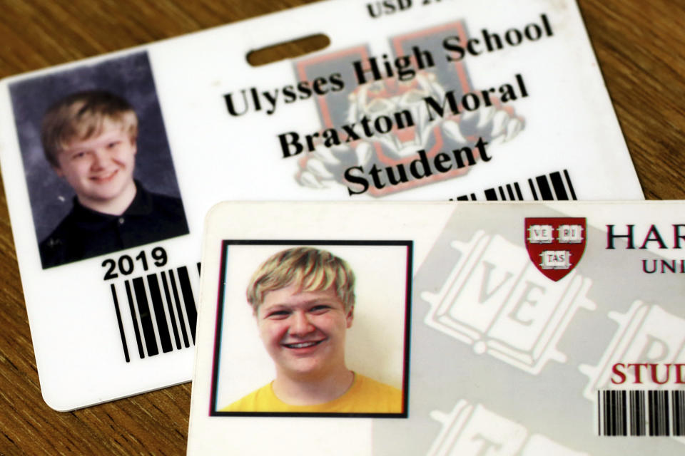 This Wednesday, Dec. 12, 2018 photo shows the high school and Harvard University identification cards which Ulysses High School senior Braxton Moral carries because he is currently attending both schools concurrently. Moral has been a Harvard University student for the past four years and will graduate in May before he graduates from high school at age 16. (Sandra J. Milburn/The Hutchinson News via AP)