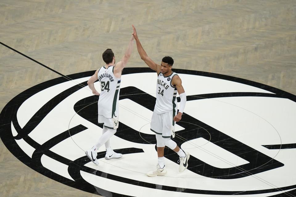 Milwaukee Bucks' Giannis Antetokounmpo (34) celebrates wth Pat Connaughton (24) after Game 7 of a second-round NBA basketball playoff series against the Brooklyn Nets, Saturday, June 19, 2021, in New York. (AP Photo/Frank Franklin II)