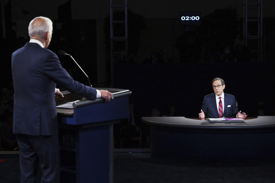 FILE - Moderator Chris Wallace of Fox News speaks as Democratic presidential candidate former Vice President Joe Biden listens during the first presidential debate in Cleveland on Sept. 29, 2020. Leaders of the Commission on Presidential Debates and moderators of all three debates gathered for a remote debrief Monday night. Two takeaways: increased early voting means the commission is considering earlier debates, and the mute button may be here to stay. (Olivier Douliery/Pool vi AP, File)