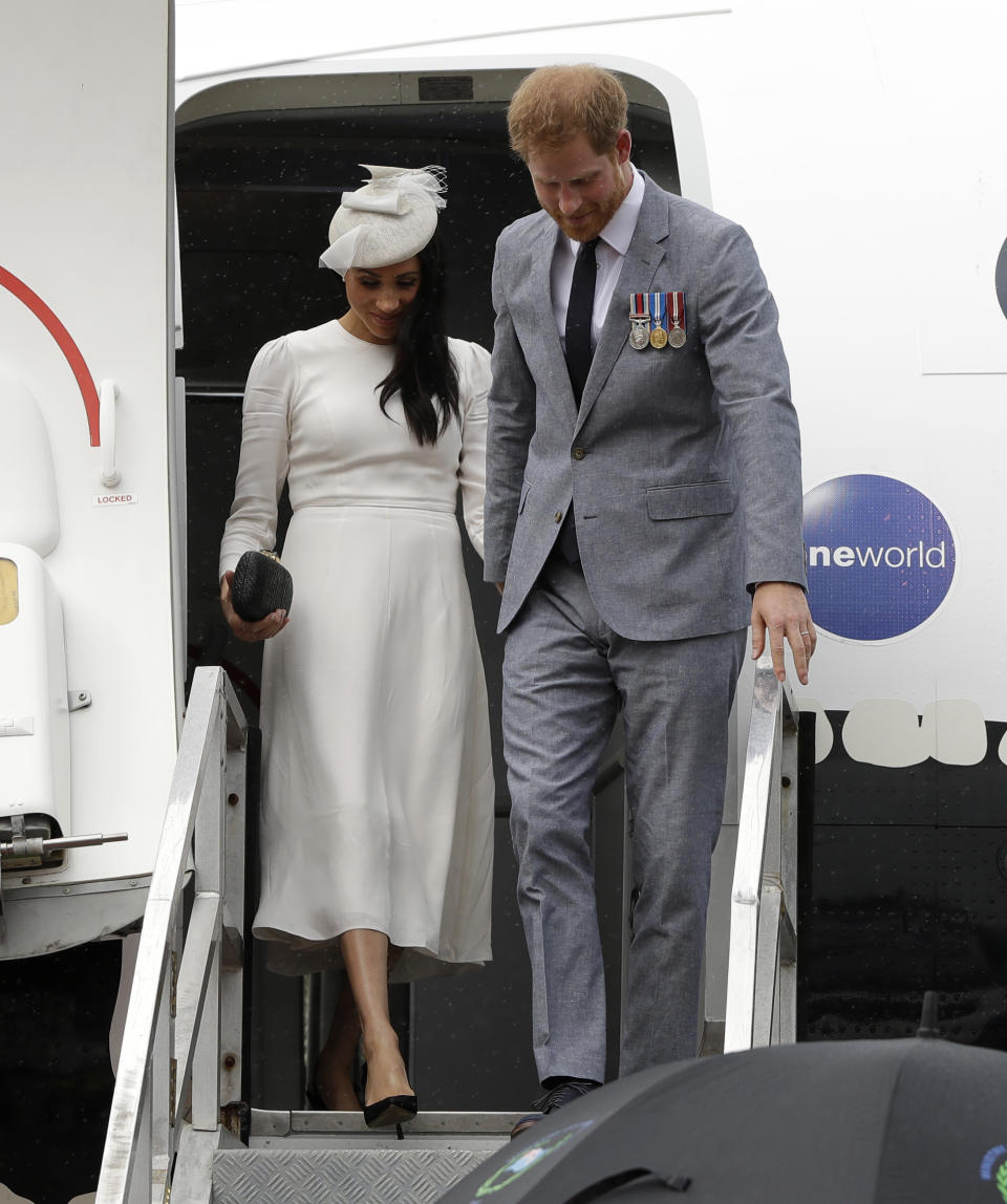 Britain's Prince Harry and Meghan, Duchess of Sussex disembark from their plane on their arrival in Suva, Fiji, Tuesday, Oct. 23, 2018. Prince Harry and his wife Meghan are on day eight of their 16-day tour of Australia and the South Pacific.(AP Photo/Kirsty Wigglesworth,Pool)