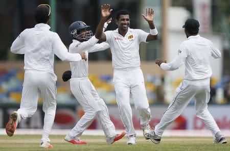 Sri Lanka's Dhammika Prasad (2nd R) celebrates with his teammates Kaushal Silva (2nd L), Tharindu Kaushal (R) and Dinesh Chandimal (L) after taking the wicket of India's Lokesh Rahul (not pictured) during the first day of their third and final test cricket match against India in Colombo, August 28, 2015. REUTERS/Dinuka Liyanawatte