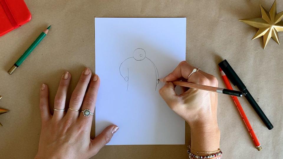 illustrator's hands drawing santa claus with a pencil